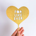 Gold heart-shaped sign with 'FOR LIKE EVER' text on a white background