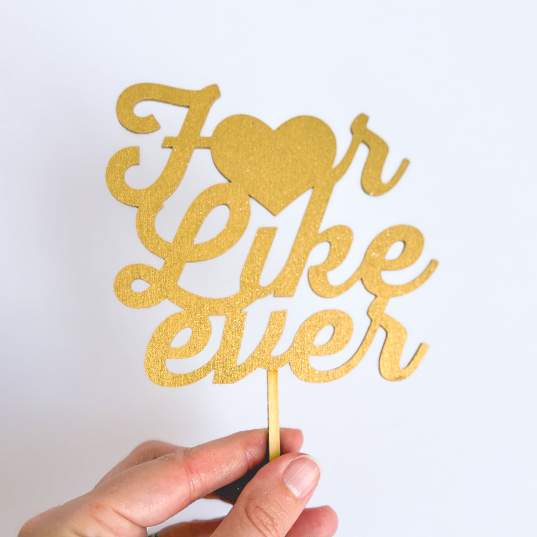 Gold glittery 'I love you' sign held by a hand against a white background