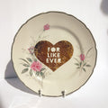 Decorative plate with a heart design and 'FOR LIKE EVER' text on a white background