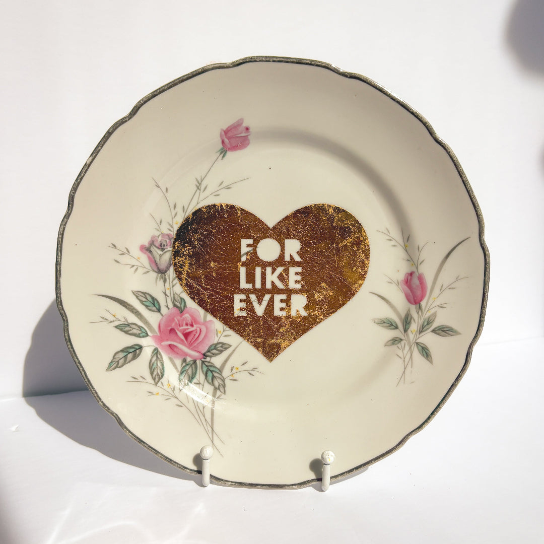 Decorative plate with a heart design and 'FOR LIKE EVER' text on a white background