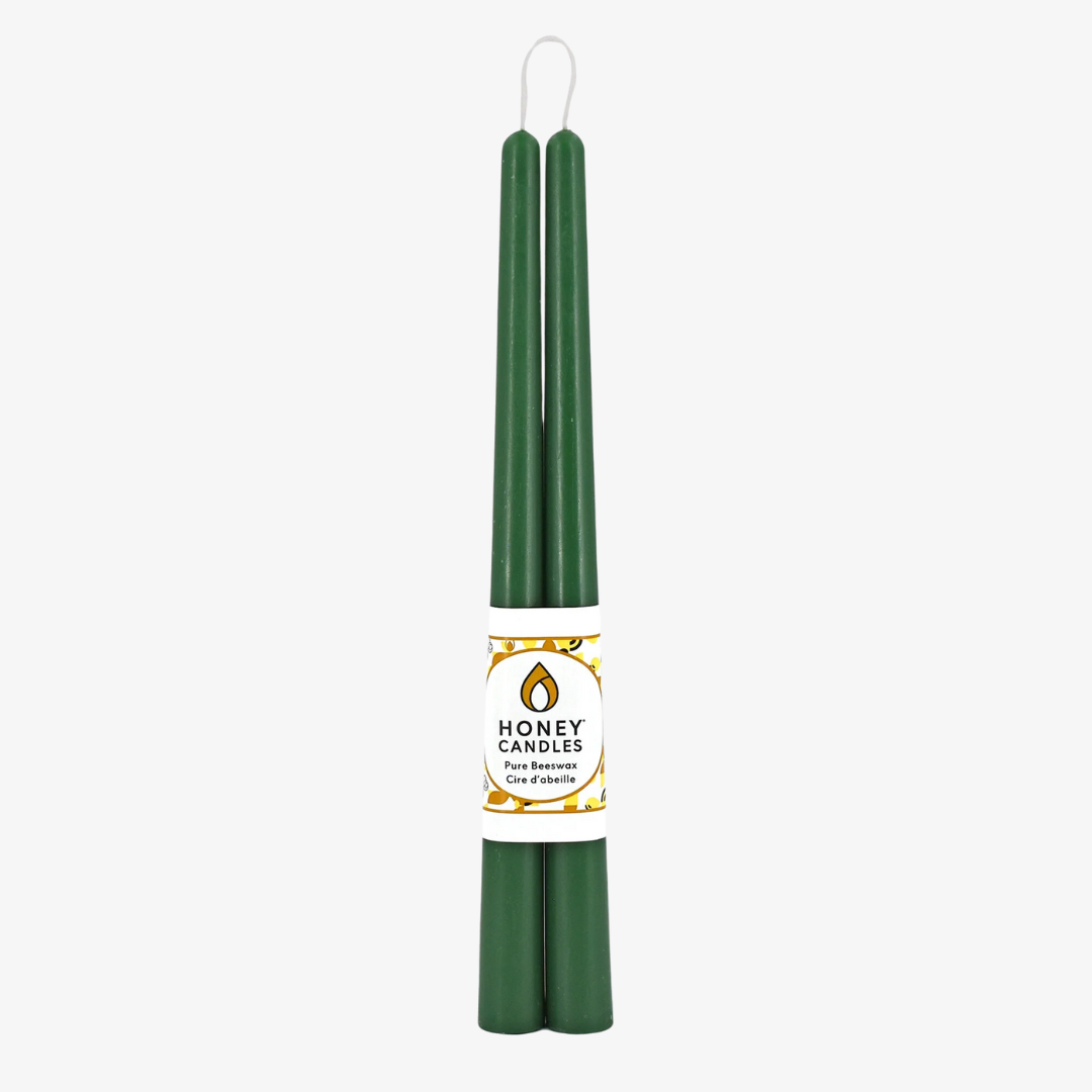 Two green beeswax candles standing upright, tied together with a string. The candles have a label that says "HONEY CANDLES Pure Beeswax."