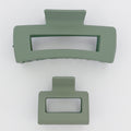 Two green hair clips on a white background