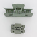Two green hair clamps on a white background