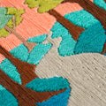 Close-up of an embroidered landscape with trees and a path.