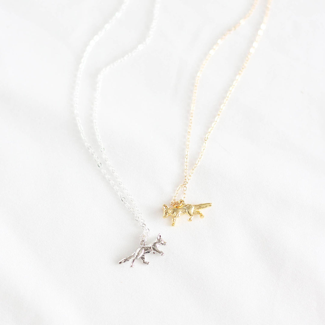 Two small animal pendants on a chain against a white background
