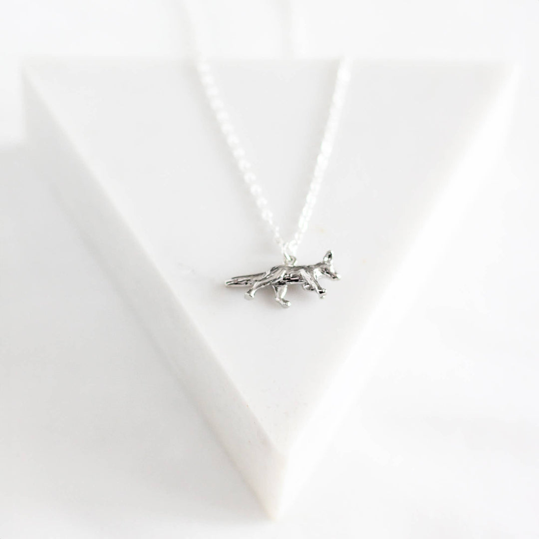 Silver fox pendant necklace on a white background