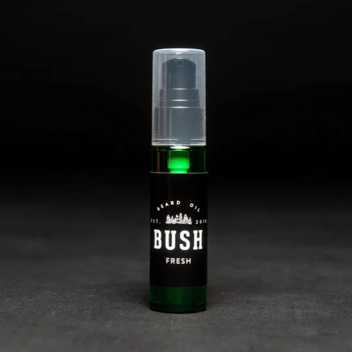 A dark green glass bottle with a black pump dispenser. The bottle is labeled 