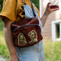 Person wearing a brown bag with embroidered designs outdoors