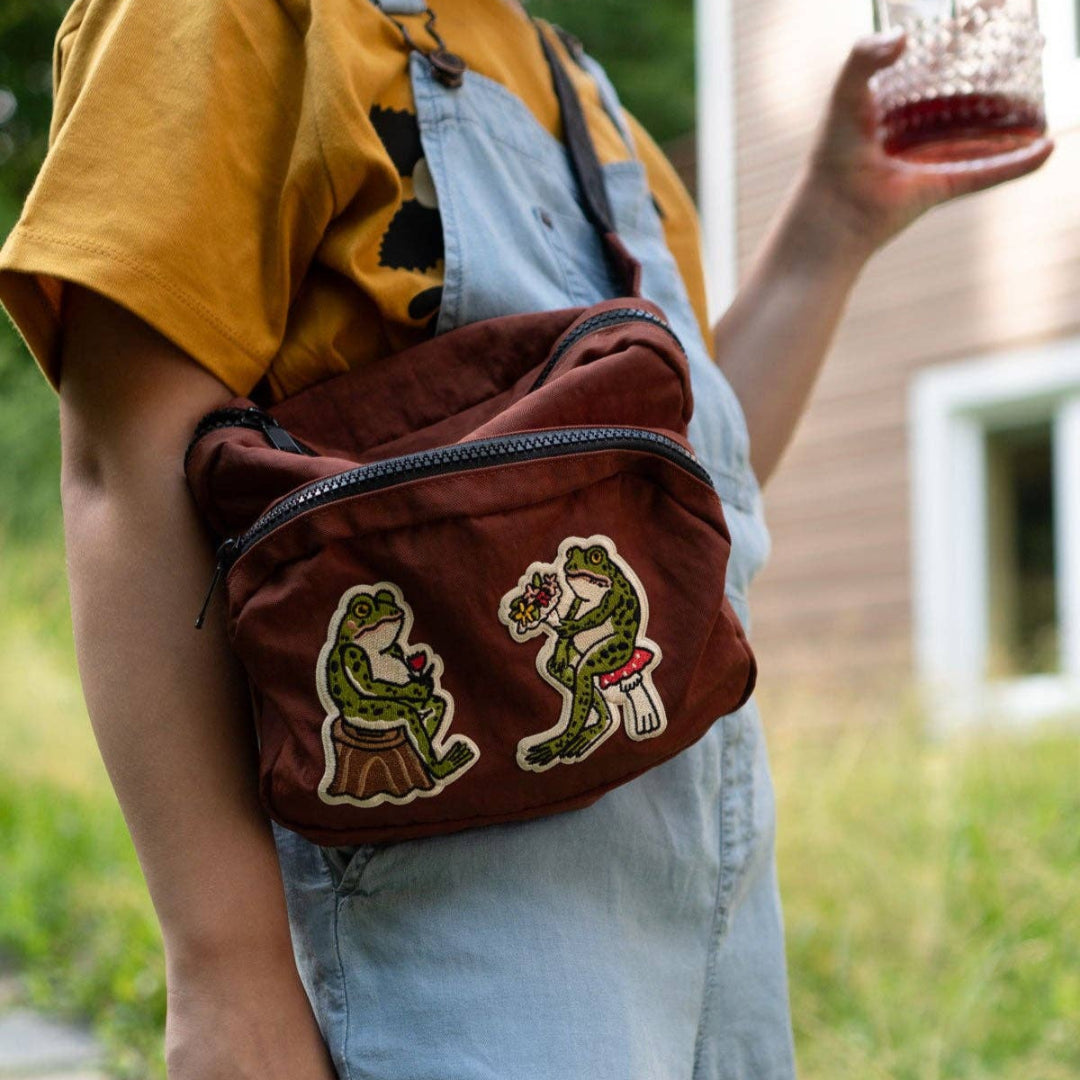 Person wearing a brown bag with embroidered designs outdoors