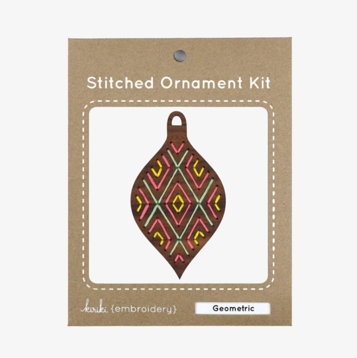 A wooden ornament shaped like a teardrop. The ornament is decorated with colorful embroidery stitches in a geometric diamond pattern.