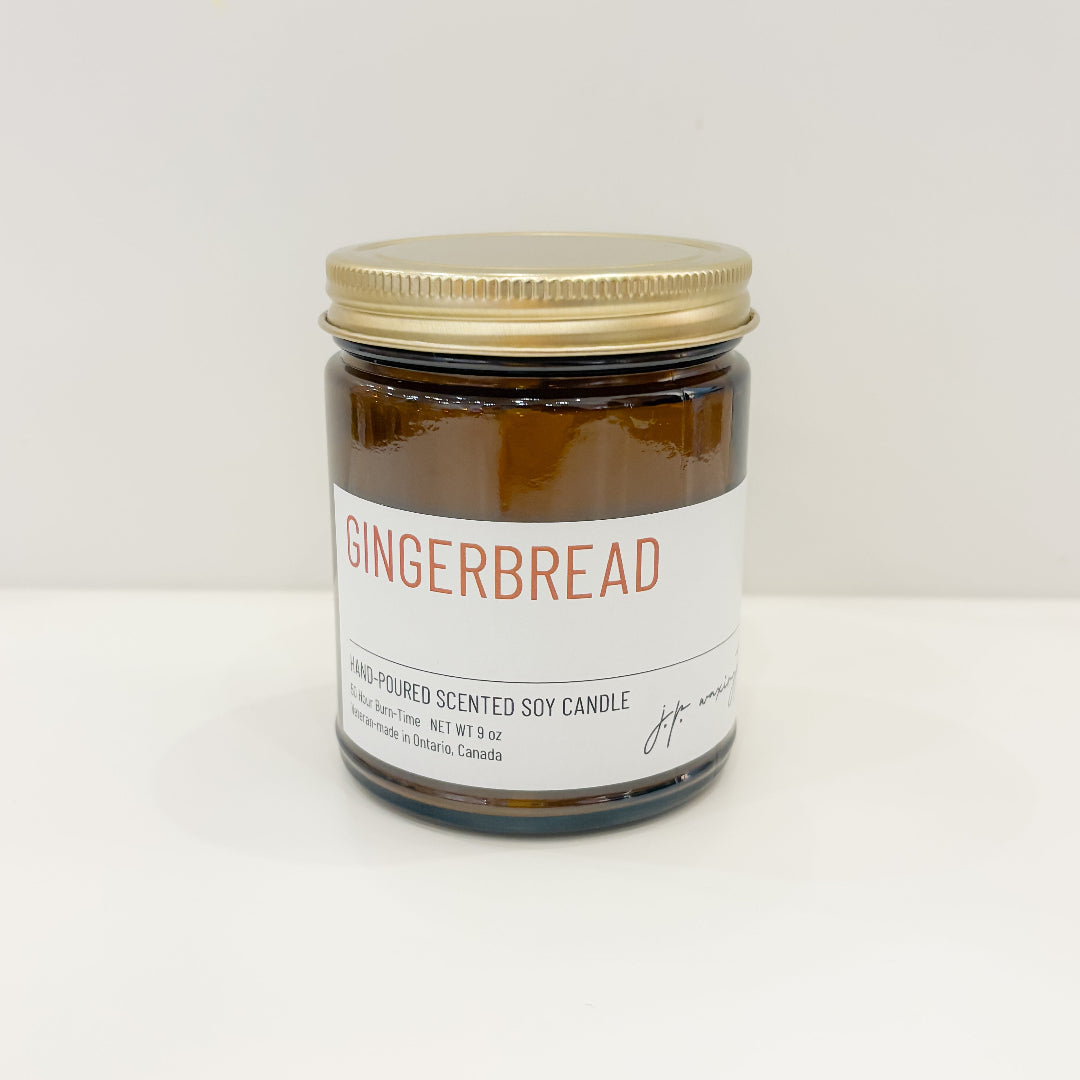 Gingerbread scented candle jar with a gold lid on a white background