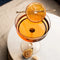 A glass jar filled with dried orange slices, cloves, and other spices. The jar has a white label with the Maiden Voyage logo and the product name 