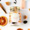 A glass jar filled with dried orange slices, cloves, and other spices. The jar has a white label with the Maiden Voyage logo and the product name 