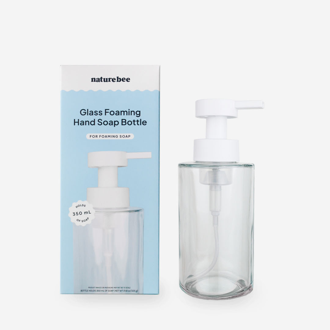 Glass foaming hand soap bottle with packaging on a white background