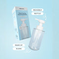 Glass foaming hand soap bottle with pump and packaging on a light blue background