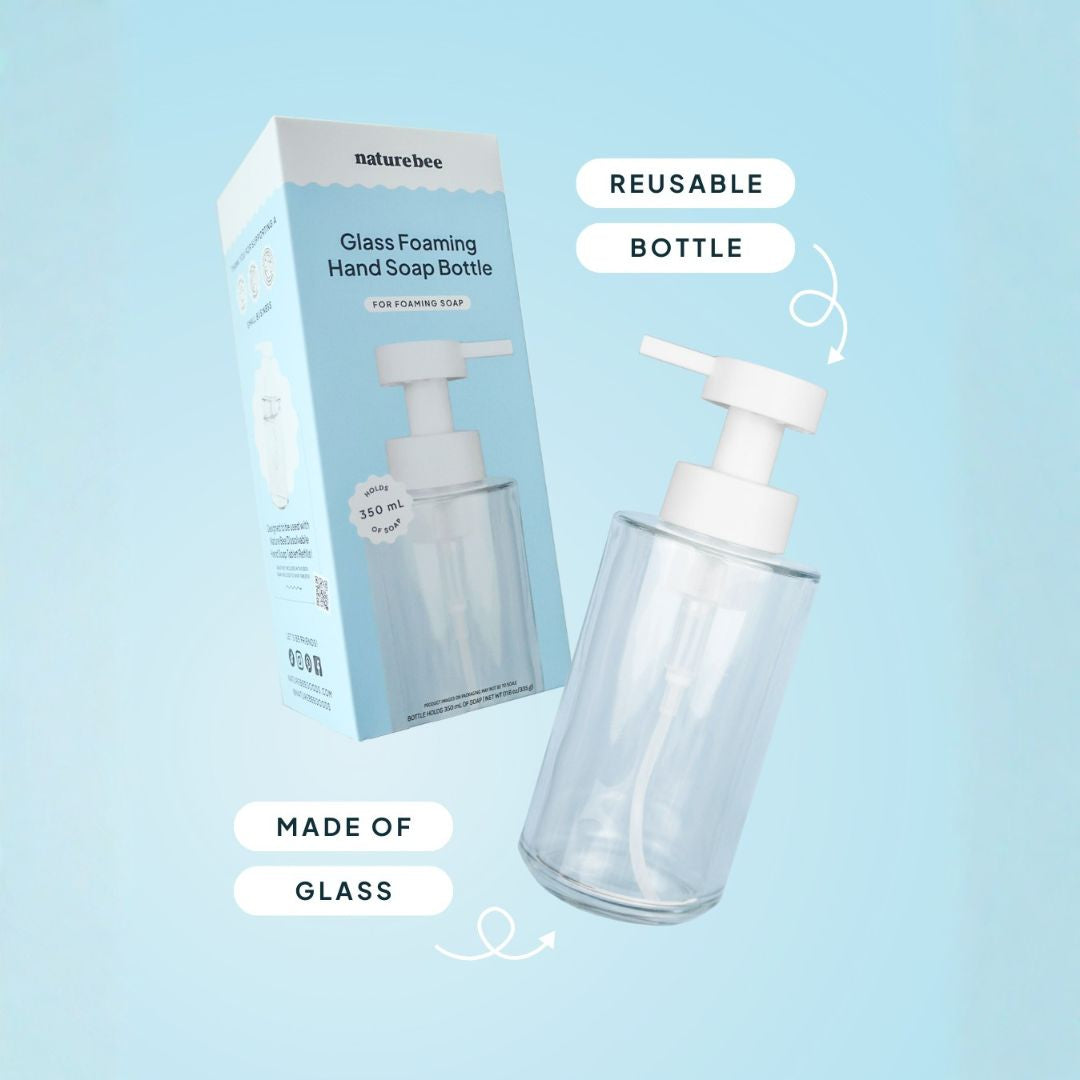 Glass foaming hand soap bottle with pump and packaging on a light blue background