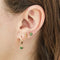 A set of three pairs of peridot earrings displayed on a green card. The set includes a pair of stud earrings, a pair of bar earrings with small peridot beads, and a pair of hoop earrings with dangling peridot stones. The card has the month 