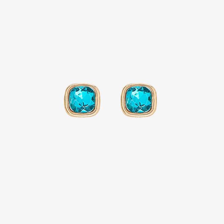 A set of three pairs of turquoise earrings displayed on a blue card. The set includes a pair of stud earrings, a pair of bar earrings with small turquoise beads, and a pair of hoop earrings with dangling turquoise stones. The card has the month 