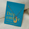 A gold necklace with a turquoise stone pendant. The pendant also has the word 
