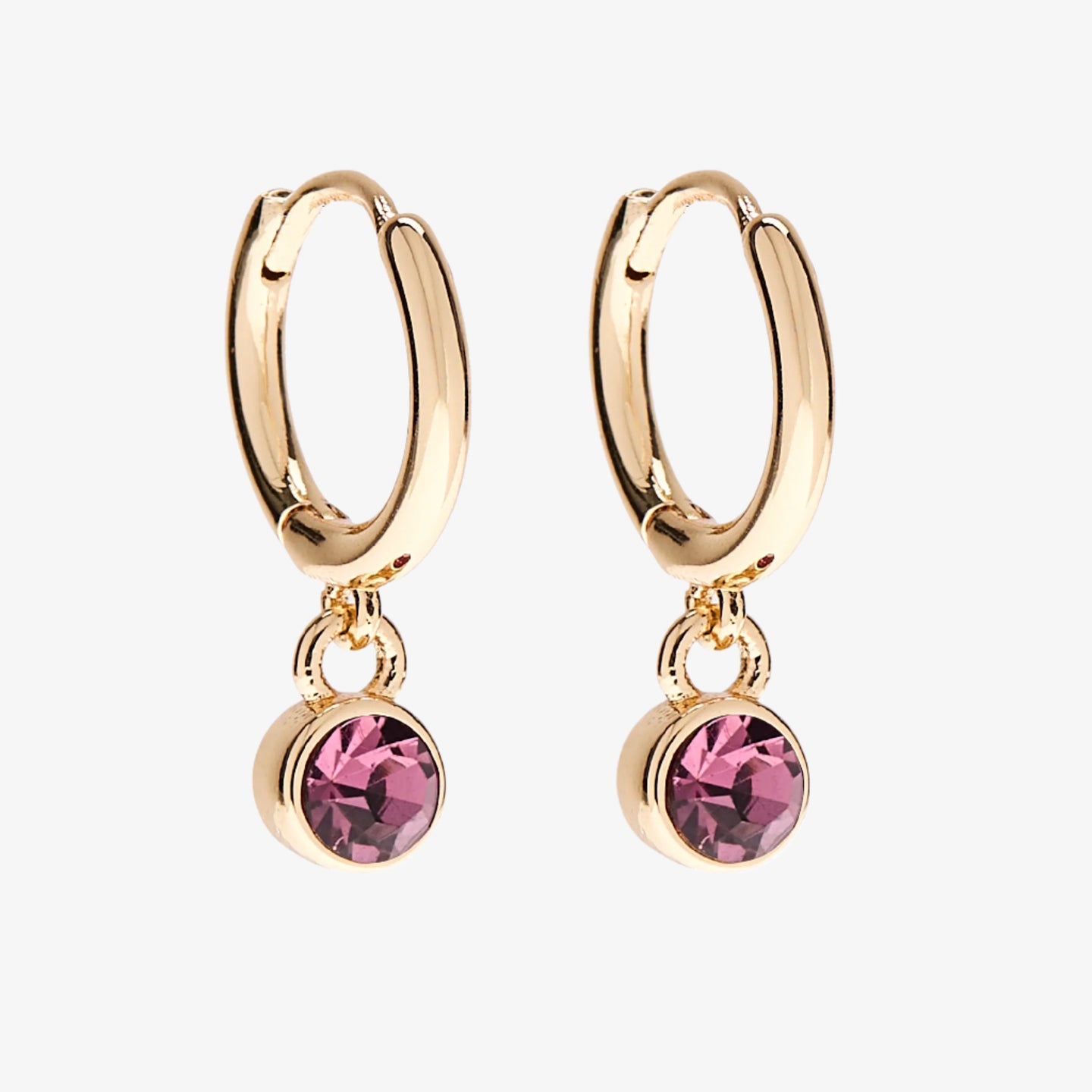 A set of three pairs of amethyst earrings displayed on a purple card. The set includes a pair of stud earrings, a pair of bar earrings with small amethyst beads, and a pair of hoop earrings with dangling amethyst stones. The card has the month "February" and the brand name "Foxy Originals."