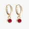 A set of three pairs of garnet earrings displayed on a red card. The set includes a pair of stud earrings, a pair of bar earrings with small garnet beads, and a pair of hoop earrings with dangling garnet stones. The card has the month 