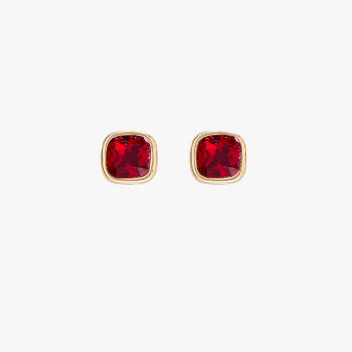 A set of three pairs of garnet earrings displayed on a red card. The set includes a pair of stud earrings, a pair of bar earrings with small garnet beads, and a pair of hoop earrings with dangling garnet stones. The card has the month 