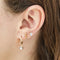 A set of three pairs of pearl earrings displayed on a blue card. The set includes a pair of stud earrings, a pair of bar earrings with small pearl beads, and a pair of hoop earrings with dangling pearl stones. The card has the month 