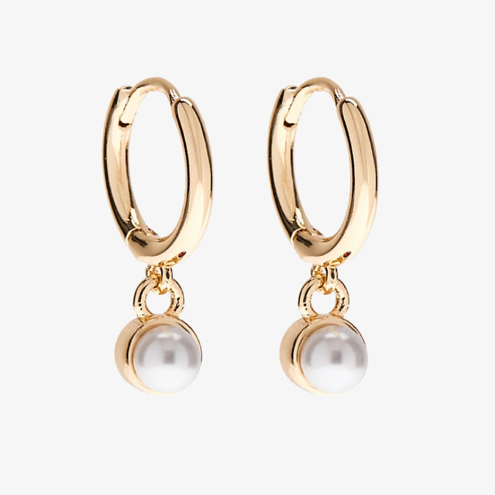 A set of three pairs of pearl earrings displayed on a blue card. The set includes a pair of stud earrings, a pair of bar earrings with small pearl beads, and a pair of hoop earrings with dangling pearl stones. The card has the month 