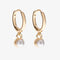 A set of three pairs of pearl earrings displayed on a blue card. The set includes a pair of stud earrings, a pair of bar earrings with small pearl beads, and a pair of hoop earrings with dangling pearl stones. The card has the month 