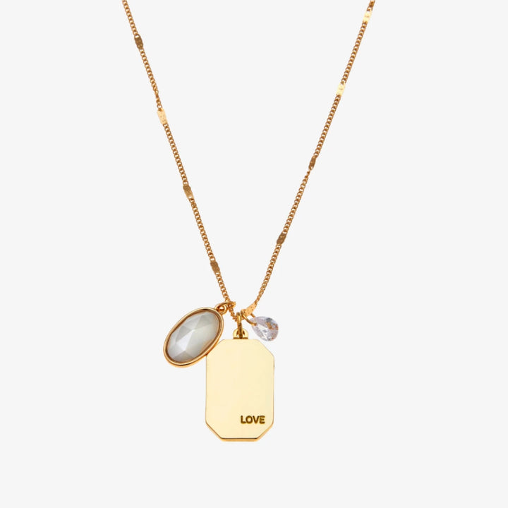 A gold necklace with a pearl stone pendant. The pendant also has the word 