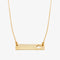 A gold necklace with a bar pendant. The bar has a cut-out maple leaf design.