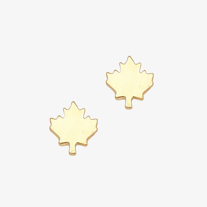 A pair of gold maple leaf stud earrings.