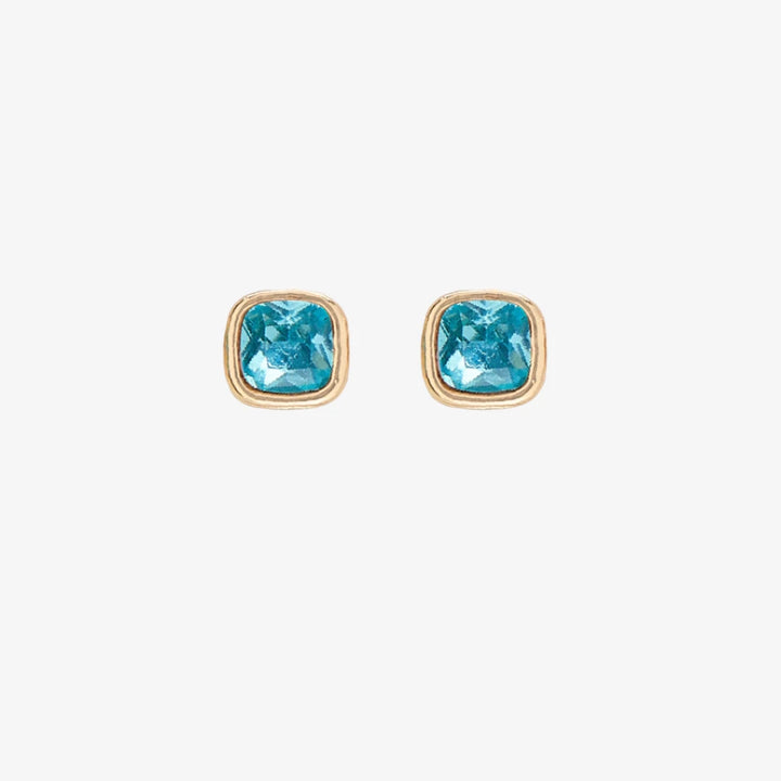 A set of three pairs of aquamarine earrings displayed on a light blue card. The set includes a pair of stud earrings, a pair of bar earrings with small aquamarine beads, and a pair of hoop earrings with dangling aquamarine stones. The card has the month 