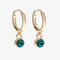 A set of three pairs of emerald earrings displayed on a green card. The set includes a pair of stud earrings, a pair of bar earrings with small emerald beads, and a pair of hoop earrings with dangling emerald stones. The card has the month "May" and the brand name "Foxy Originals."