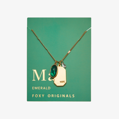 A gold necklace with an emerald stone pendant. The pendant also has the word 