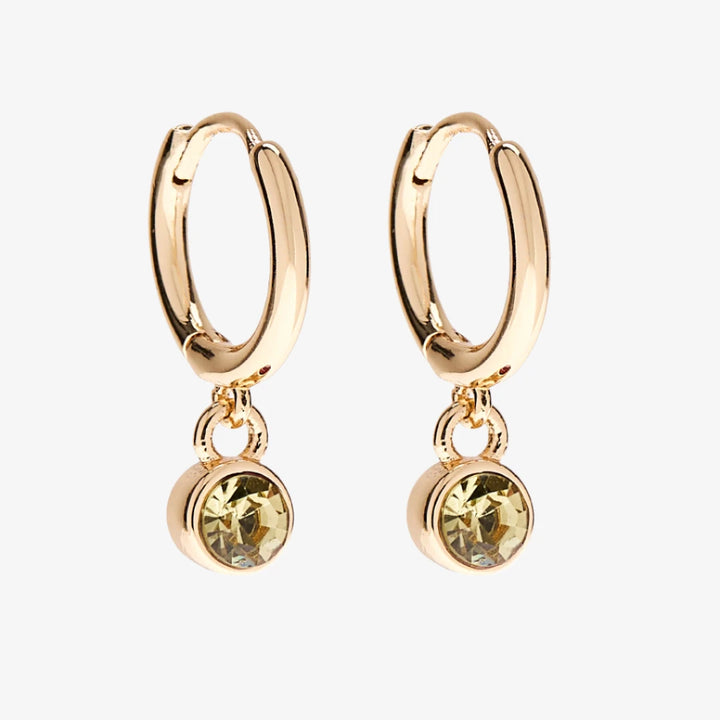 A set of three pairs of citrine earrings displayed on a yellow card. The set includes a pair of stud earrings, a pair of bar earrings with small citrine beads, and a pair of hoop earrings with dangling citrine stones. The card has the month 
