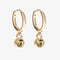 A set of three pairs of citrine earrings displayed on a yellow card. The set includes a pair of stud earrings, a pair of bar earrings with small citrine beads, and a pair of hoop earrings with dangling citrine stones. The card has the month 