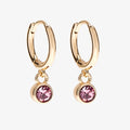 A set of three pairs of opal earrings displayed on a pink card. The set includes a pair of stud earrings, a pair of bar earrings with small opal beads, and a pair of hoop earrings with dangling opal stones. The card has the month "October" and the brand name "Foxy Originals."