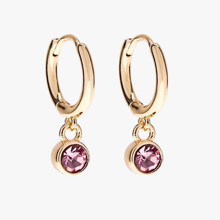 A set of three pairs of opal earrings displayed on a pink card. The set includes a pair of stud earrings, a pair of bar earrings with small opal beads, and a pair of hoop earrings with dangling opal stones. The card has the month 
