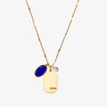 A gold necklace with a sapphire stone pendant. The pendant also has the word "TRUTH" engraved on it. The necklace is displayed on a blue card with the month "September" and the brand name "Foxy Originals."