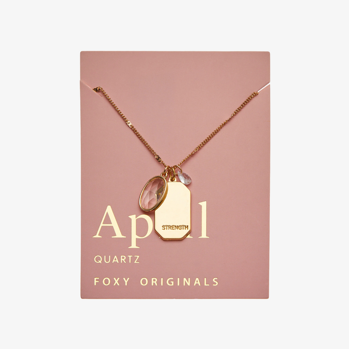 A gold necklace with a quartz stone pendant. The pendant also has the word 
