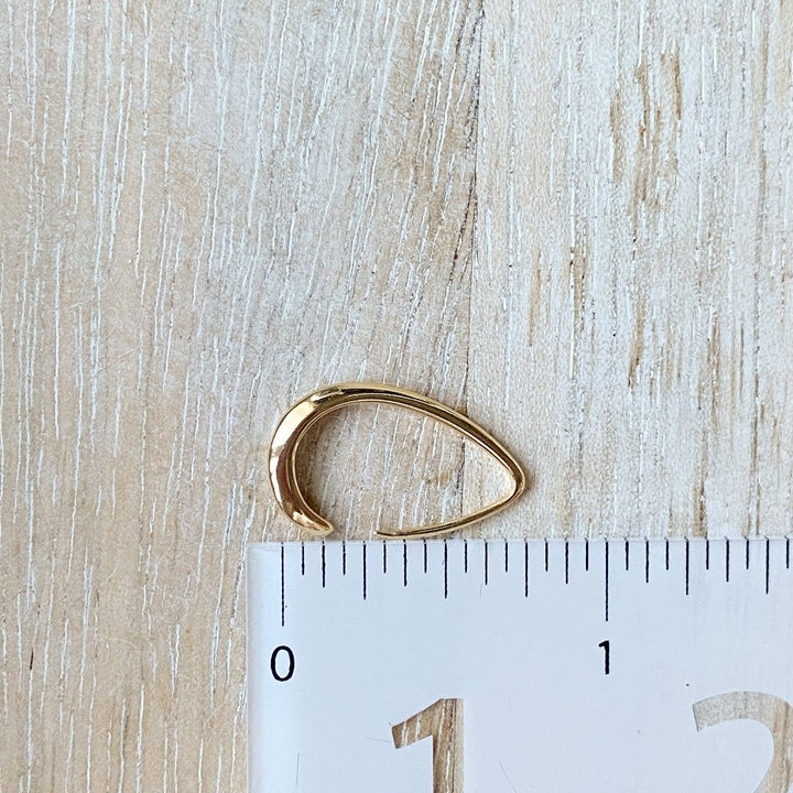 A pair of Agaveh Girl Gold Aspyn Hoops, featuring a minimalist, open curved design, displayed on a branded card with the text 'agaveh girl,' against a textured background. The earrings are dainty and modern, available in Ottawa, Ontario, Canada.