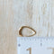 A pair of Agaveh Girl Gold Aspyn Hoops, featuring a minimalist, open curved design, displayed on a branded card with the text 'agaveh girl,' against a textured background. The earrings are dainty and modern, available in Ottawa, Ontario, Canada.