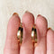 A pair of gold, double-layered hoop earrings.