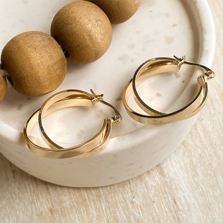 A pair of gold, double-layered hoop earrings.