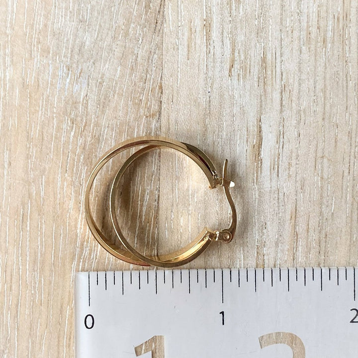 A pair of gold, double-layered hoop earrings.