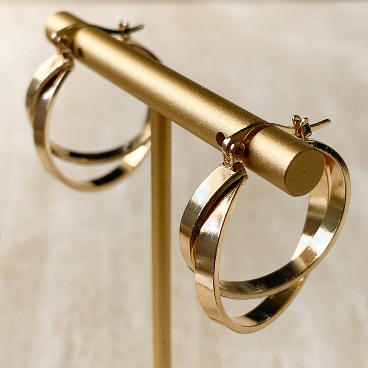 A pair of gold, double-layered hoop earrings.