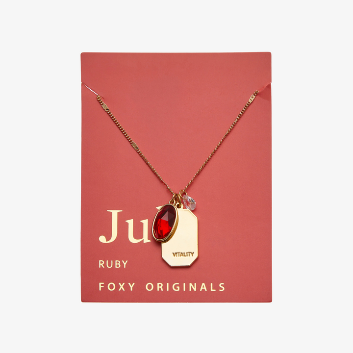 A gold necklace with a ruby stone pendant. The pendant also has the word 