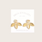 A pair of gold earrings with a leaf design. The earrings have a white, circular resin center with gold flecks. The leaves are attached to the center and can be detached.