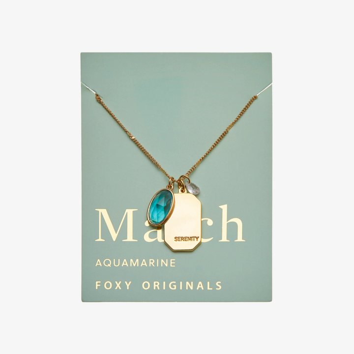 A gold necklace with an aquamarine stone pendant. The pendant also has the word 